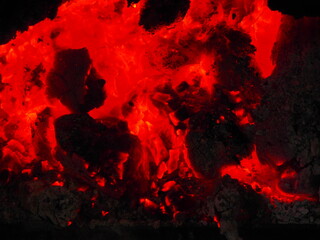 Reddish embers and bright orange flames in the winter bonfire.