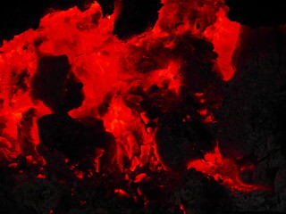 Fototapeta premium Reddish embers and bright orange flames in the winter bonfire.