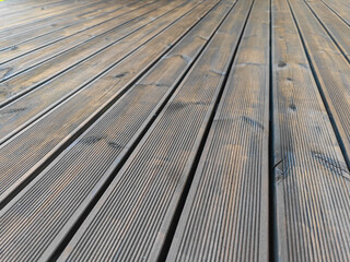 Fluted pine wood terrace freshly impregnated with dark brown oil. Decking of renovated old wooden...