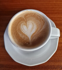 Top view of a cup of cappuccino with a heart of milk foam