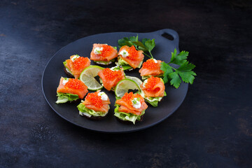 Traditionelle Pumpernickel Taler mit Räucherlachs und Kaviar serviert als Häppchen auch einem Design Teller mit Textfreiraum