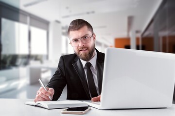 Middle aged professional businessman sitting at desk in office