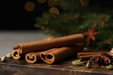 Board with different aromatic spices on table, closeup