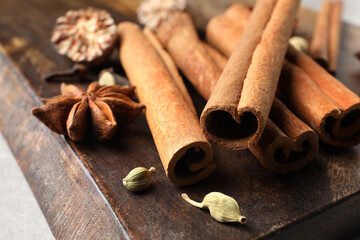 Board with different aromatic spices on light table, closeup