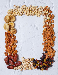Mixed nuts and dried fruits on a light concrete background. Symbols of Tu Bishva