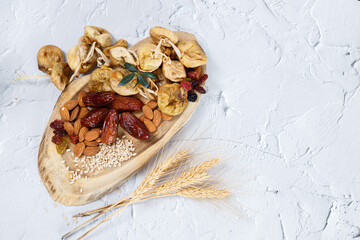 Mixed nuts and dried fruits on a light concrete background. Symbols of Tu Bishva