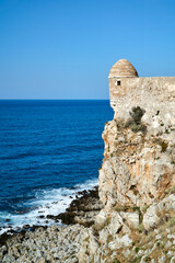 The walls of a Venetian, medieval fortress have a sea shore in the city of Rethymnon on the island of Crete