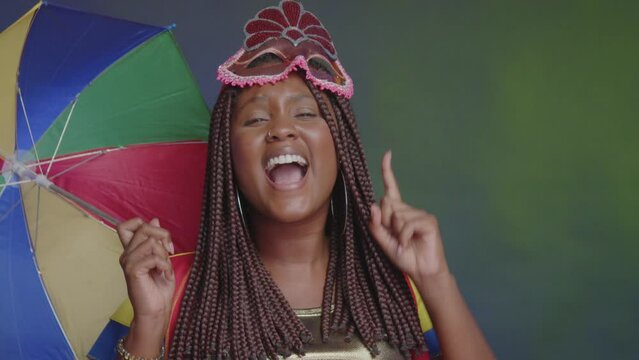 Black Brazilian woman, in frevo clothes, carnival. dancing scene close-up on face.