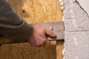 Precise Plank Placement in Meticulously Notched Wooden Frame by Skilled Hands.