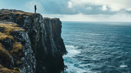 Fototapeta na wymiar Person stood on a cliff overlooking the sea