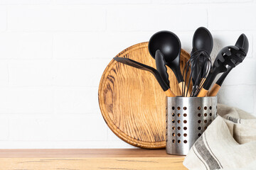 Kitchen utensils. Cooking tools with wooden cutting boards, oil and shaker at white modern kitchen...