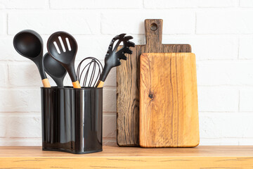 Kitchen utensils. Cooking tools with wooden cutting boards, oil and shaker at white modern kitchen...