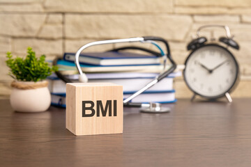 the word Body mass index is written on wooden cubes near a stethoscope on a wooden background....