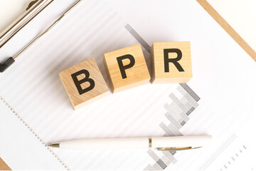wooden blocks with the word BPR stand on financial background with chart and pen, business concept