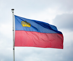 Flag of Liechtenstein waving on cloudy sky background
