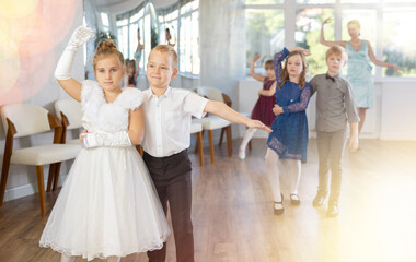 Children dance in pairs at a festive matinee