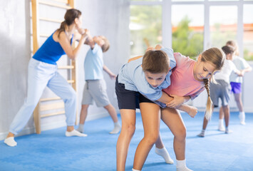 Young jiu jitsu students are fine-tuning their striking techniques in dojo.