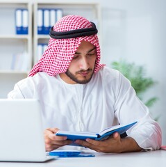 Arab businessman working in the office doing paperwork with a pi