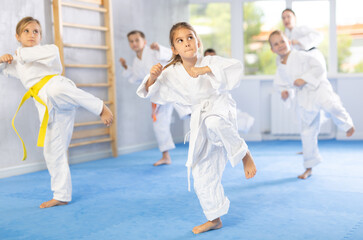 Children athletes starting position and studying and repeating sequence of punches and painful...