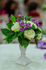 a flower vase decorated with white and purple flowers