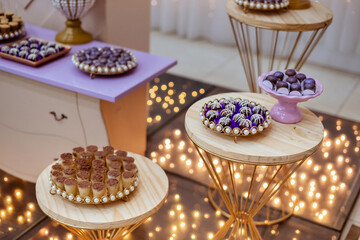 a table decorated with wedding sweets LED lights in the background