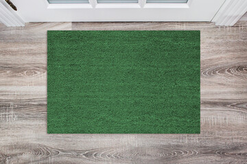 Green Coir Doormat on a wooden floor in front of the door. Product mockup