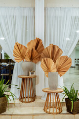two wooden stools with white porcelain vases and natural leaves decorating