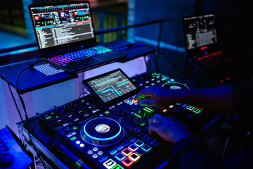 a dj soundboard with lights on and a man's hand controlling