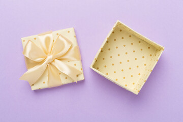Beige open gift box on color background, top view