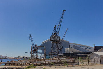 Fototapeta na wymiar Alte Hafenkräne vor moderner Lagerhalle im Hafen von Fremantle