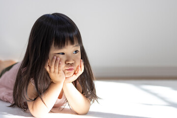 寝転がる不機嫌な女の子の様子（3歳、日本人） - obrazy, fototapety, plakaty