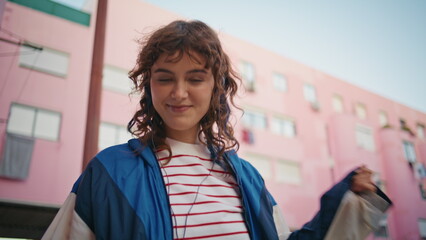 Urban woman dancing song wearing headphones close up. Happy girl listening music