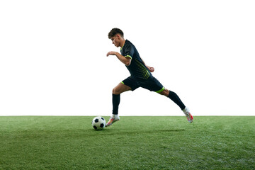 Young man, football player in motion during game, running with ball isolated over white background with grass flooring. Concept of sport, game, competition, championship, active lifestyle