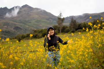 Fototapeta na wymiar Un turista con mochila, gorra y celular en el paraíso floral, encanto primaveral, tecnología y flores amarillas en armonía.