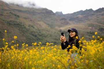 Retrato de una hermosa chica turista con gorra mirando el móvil en el hermoso paisaje, revisando...
