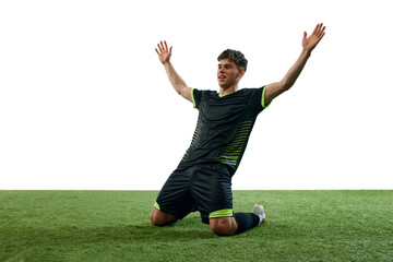 Successful, winning game. Young man, soccer player expressing emotions of win isolated over white background with grass flooring. Concept of sport, game, competition, championship, active lifestyle