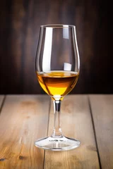 Fotobehang Glass of amber-colored sherry wine on wooden surface © Kondor83