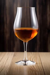 Fotobehang Glass of amber-colored sherry wine on wooden surface © Kondor83