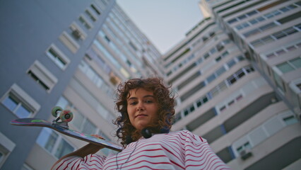 Girl posing skate board looking camera on street close up. Woman with skateboard © stockbusters