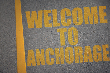 asphalt road with text welcome to Anchorage near yellow line.