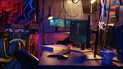 Dolly out shot of empty messy hackers base of operations with neon lights and graffiti drawings...