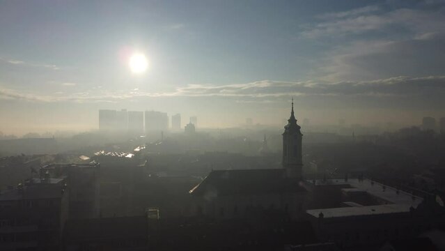 Drone flight above the church in the smog and fog in the morning. Zemun and New Belgrade district, Belgrade, Serbia, Europe.