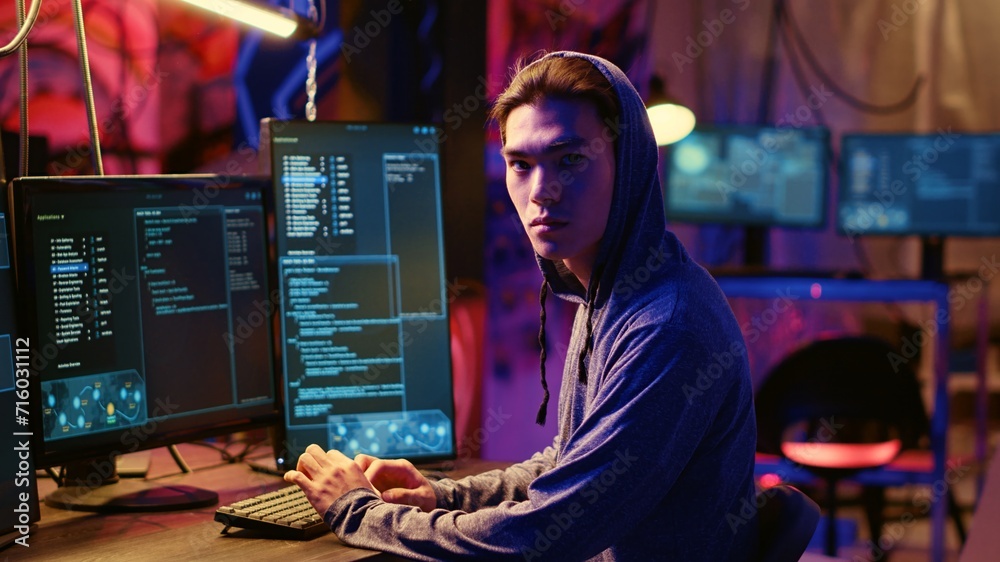 Poster portrait of asian hacker building spyware software designed to gather information from users compute