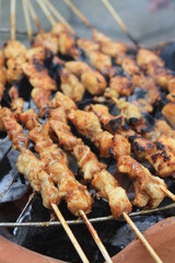 The process of grilling chicken satay on a traditional stove