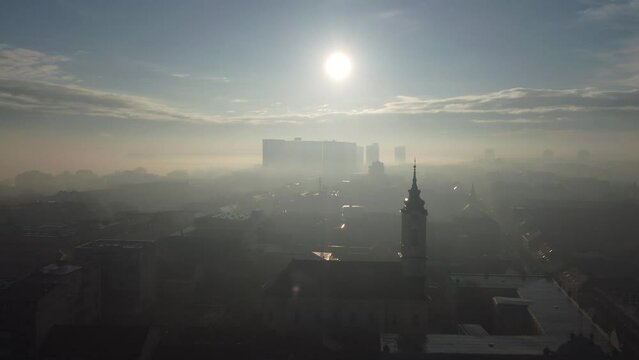 Drone flight above the church in the smog and fog in the morning. Zemun and New Belgrade district, Belgrade, Serbia, Europe.