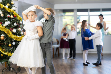 Viennese waltz performed by beautifully dressed children near the Christmas tree