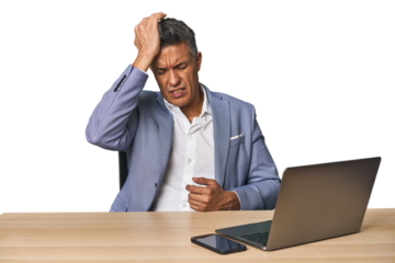 Elegant businessman at desk with laptop tired and very sleepy keeping hand on head.