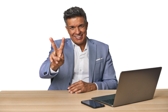 Elegant businessman at desk with laptop showing number two with fingers.