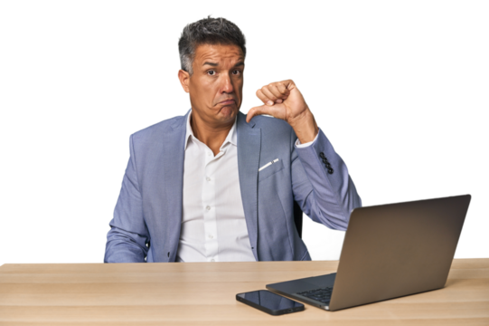Elegant businessman at desk with laptop showing thumb down, disappointment concept.