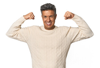 Middle-aged Latino man showing strength gesture with arms, symbol of feminine power